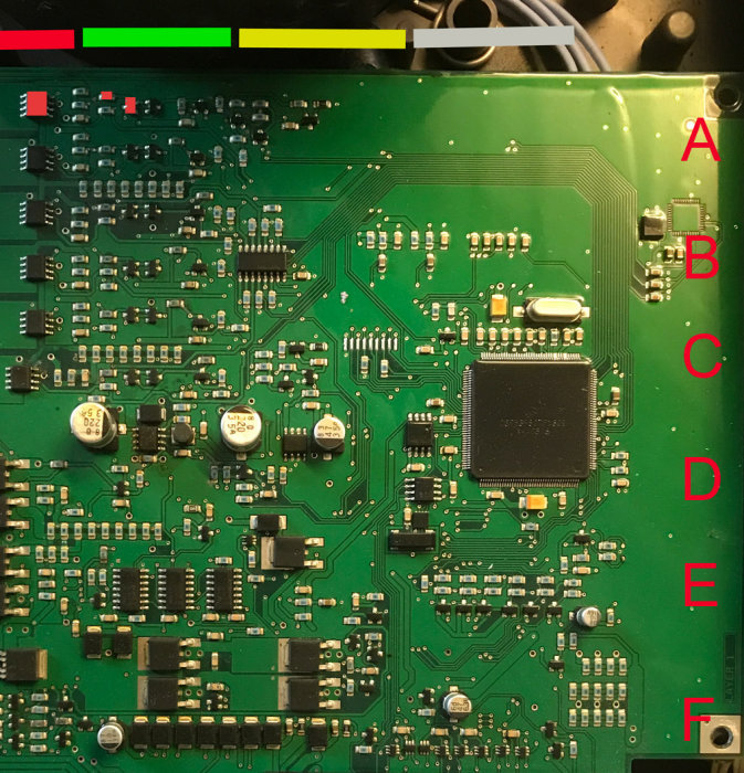 Närbild av kretskort med elektroniska komponenter och markerade sektioner A-F.
