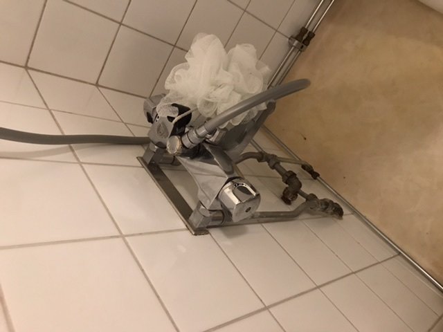Blandare och duschslang i badrum behöver höjas för installation av nytt badkar.