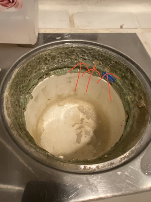 Avloppshål med grönt tätskikt, lossnat material vid pilarna, och frågetecken vid avsaknad av brunnsmanschett.