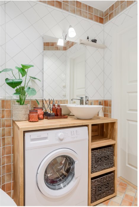 Tvättmaskin under en trång arbetsbänk i ett kaklat badrum med synlig skakproblematik.
