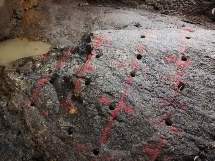 Markeringar och hålborrningar i en betonggrund under renovering.