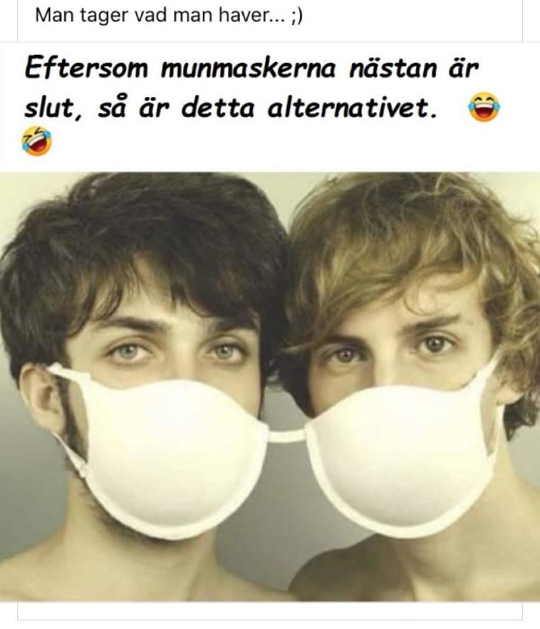 Två personer som delar en munskyddsmask mellan sig på ett komiskt sätt.