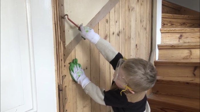 Barn hjälper till med rivning i en trappa, bär skyddsglasögon och arbetshandskar.