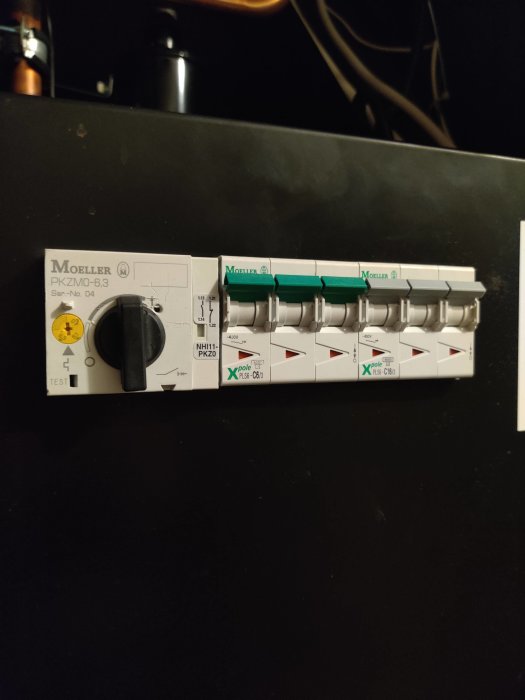 Elektrisk kapsling med en Moeller motorskyddsbrytare och påmonterade säkringshållare, ej utlöst.