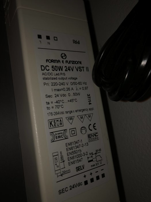 En närbild av en etikett på en AC/DC LED-drivare med tekniska specifikationer och säkerhetsmärkningar.