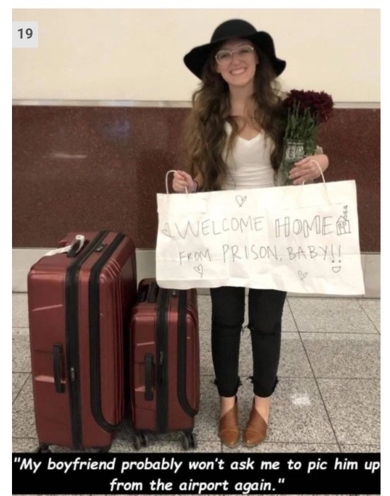 Kvinna på flygplats med skylt "Welcome home from prison" och blommor, står bredvid resväskor.