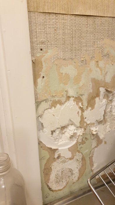Vägg med ojämnt underlag av möjligt gips och spackel, fråga om putsbruk lämplighet.