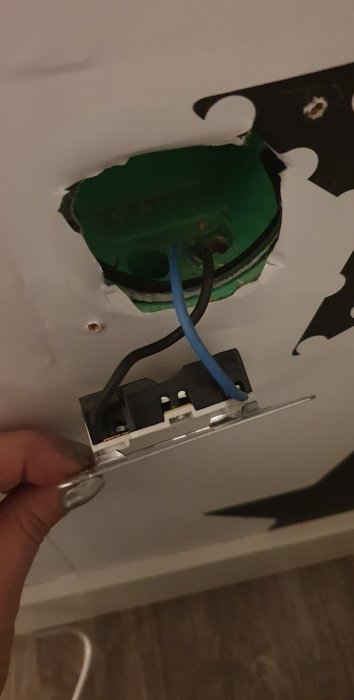 Installation av Clas Ohlson vägguttag med blå kabel och öppen dosa i vägg.