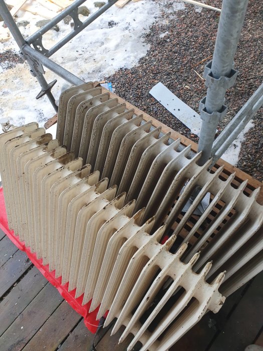 Staplad gammal gjutjärnsradiator redo för installation.