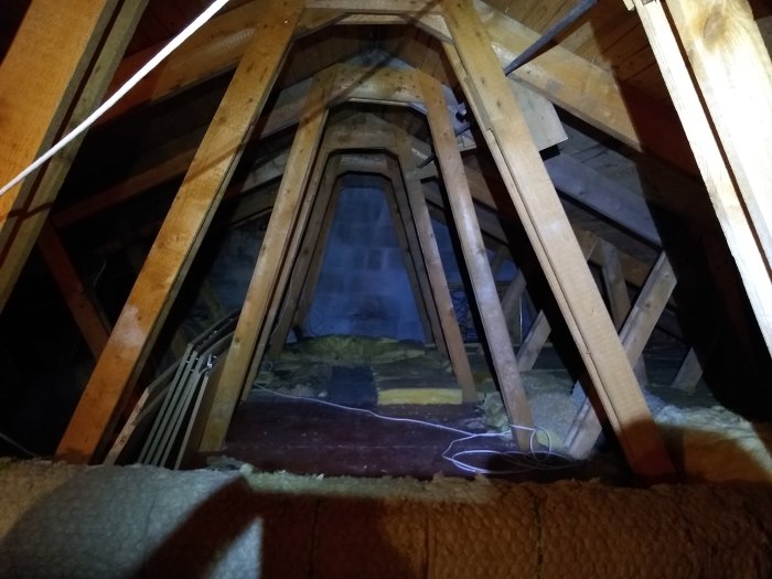 Takstolens inre struktur i ett hus från 1959, synliga träbalkar och isolering under konstruktionen.