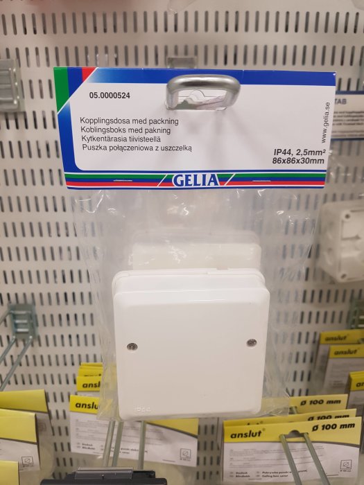 Förpackad kopplingsdosa med packning hängande på en butikshylla, modell IP44, märkt för användning i byggprojekt.