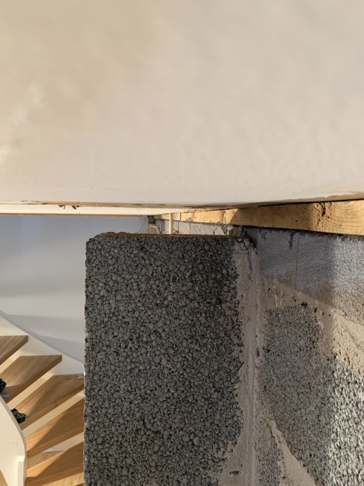 Pelare i källare med synlig glipa upp mot taket, bredvid reglad vägg; ingen synlig last ovanifrån.