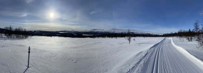 Panoramavy över snötäckt landskap i Funäsdalen-Tänndalen med preparerade skidspår och fjäll i bakgrunden.