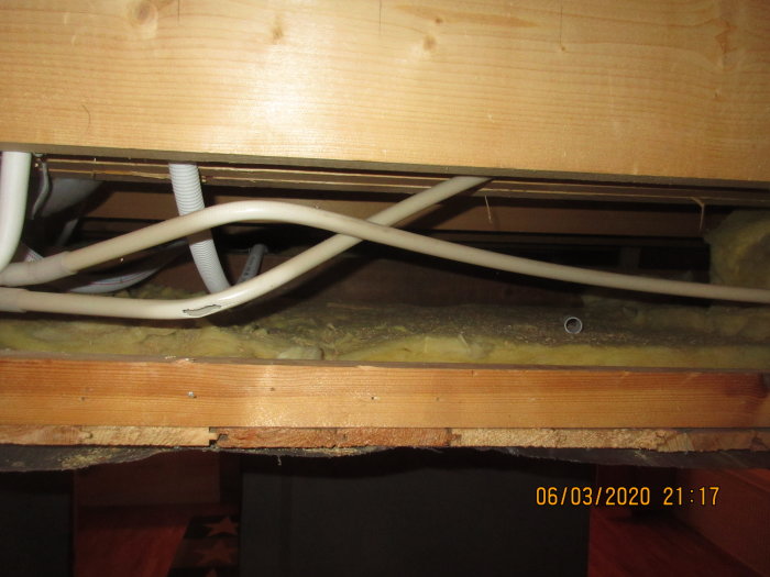 Utrymme under innertak med synliga elledningar och installationsrör för planerad belysning och elektricitet.