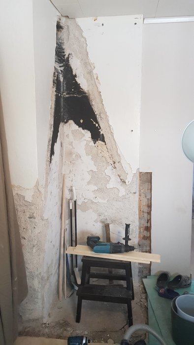 Renoveringsarbete där en gammal öppenspis rivits ut och väggen förbereds för gips.