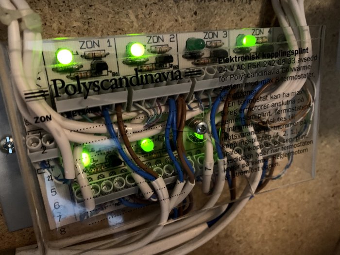 Elektronisk kopplingsplint för golvvärmesystem med gröna lysdioder och etiketten "Polyscandinavia".