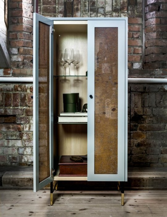 Öppen garderob med perforerad dörr av MDF-skivor och gångjärn, innehållande hyllor och glas.