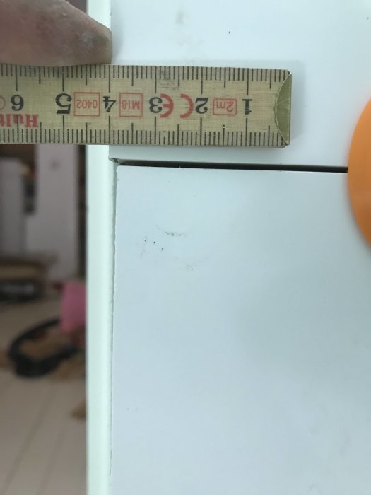 Mätning av kaklets tjocklek med tumstock för att bedöma slipning med diamantslipkloss.