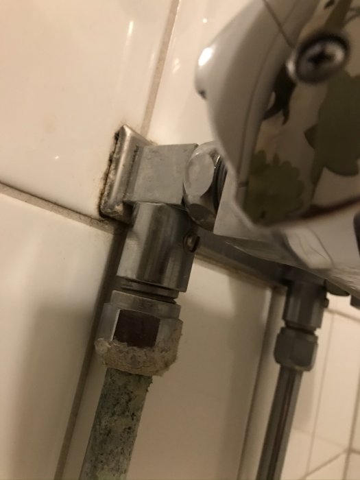 Bild på blandarfäste med inbyggda avstängningsventiler under ett handfat.
