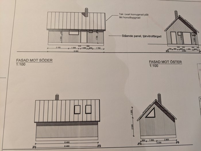 Arkitektritningar av husfasader med måttangivelser, sydväst och österut, med tak i svart plåt och stående träpanel.