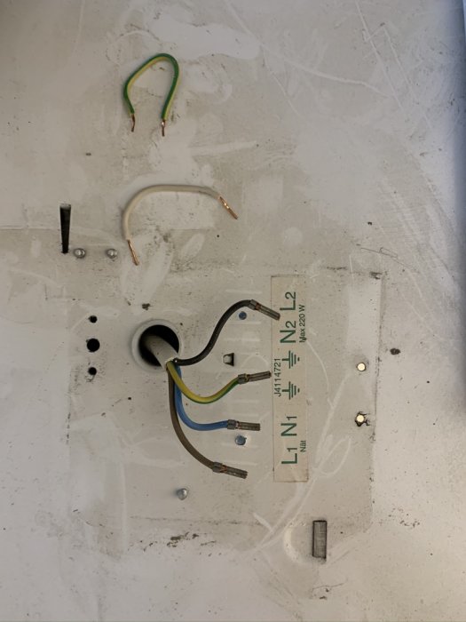 Elanslutningar för en köksfläkt med utsatta kablar markerade L, N1, N2 och en jordanslutning, redo för installation.