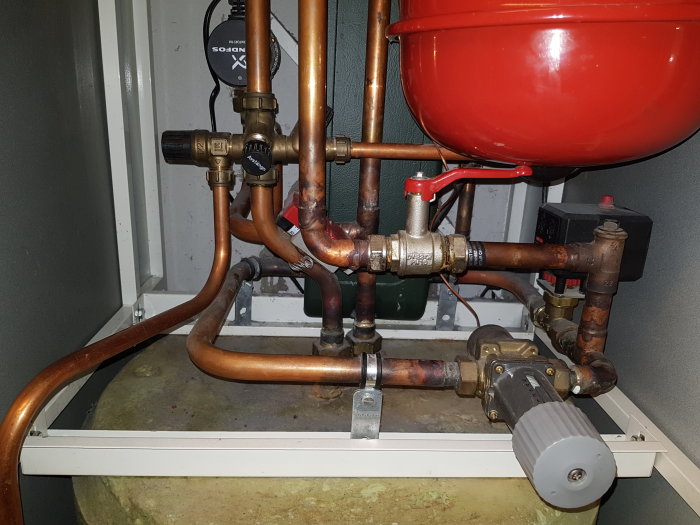 Varmvattenberedare och anslutna rör och ventiler i en teknisk installation.