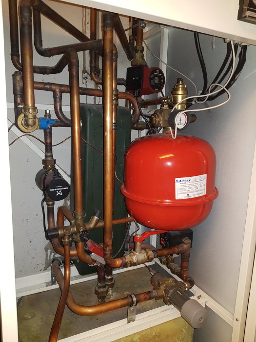 Värmesystem med varmvattenberedare, expansionskärl, pump och kopparledningar.