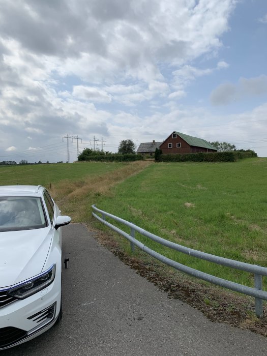 Hus och lada på landsbygd med parkerad bil, ladan ska renoveras och huset rivas för nybygge.