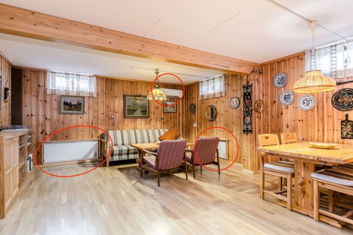 Källarvåning med träpanel och el-element under fönster och luftvärmepump på vägg, diskuterad i byggforumsinlägg.