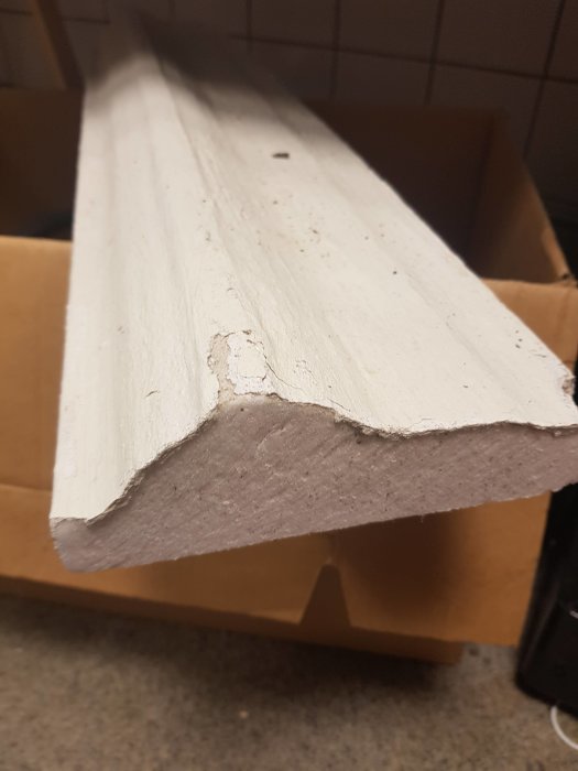 Skadad cellplastprofil med putsfärg för fönsterinstallation.