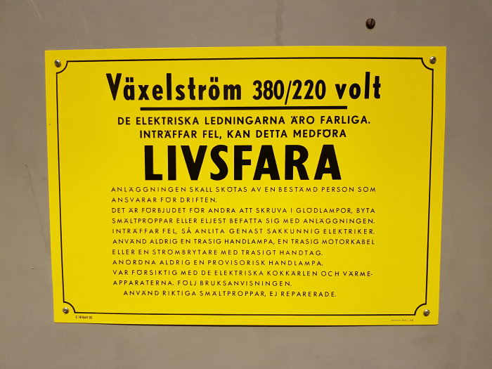 Gul varningsskylt med text "Växelström 380/220 volt" och säkerhetsinstruktioner om elektriska anläggningar.