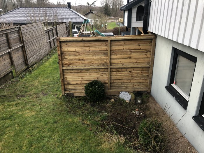 Ny trall och förberedd plats för robotgräsklipparens station vid hus och staket.