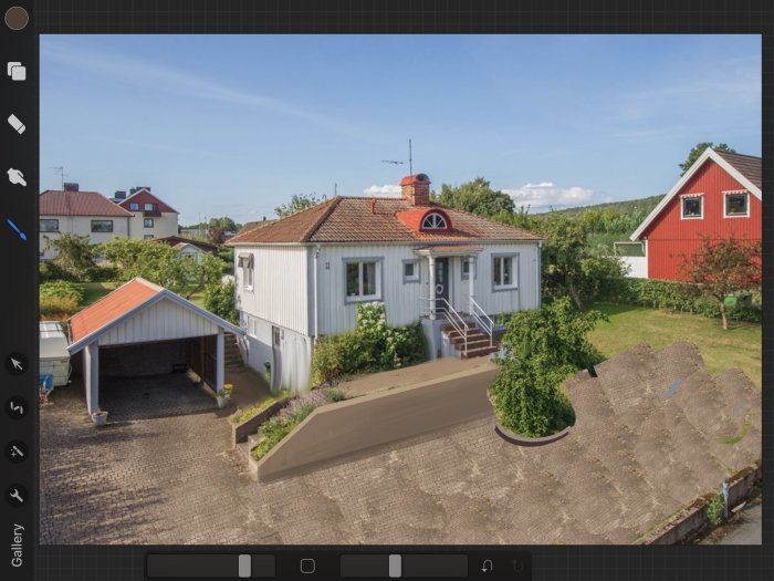 Vit husfasad med rött tak och carport, framsidan planerad för bilparkering och framtida attefallshus.