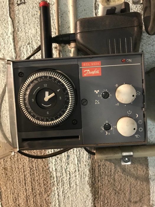 Danfoss ECL 9324 värmecontrollers panel med tidsur, termostatknappar och på/av-indikator.