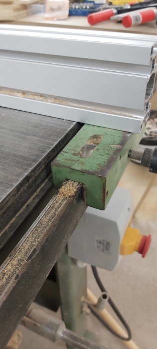 Modifierat grönt anhåll på en såg med aluminiumprofil och skruvar för justering.