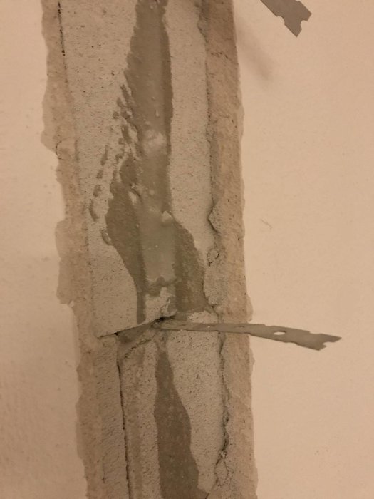 Slarvigt spacklad vägg där en mellanvägg avlägsnats, exponerar ytan mellan lättbetongblock och yttervägg.