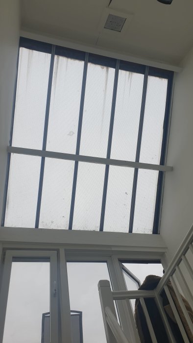 Glasstak konstruktion över trapphus med synliga smuts och ojämnheter på skivorna.