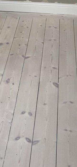 Trägolv behandlat med lut och hårdvaxolja utan fogar mellan planken, ser strävt ut.