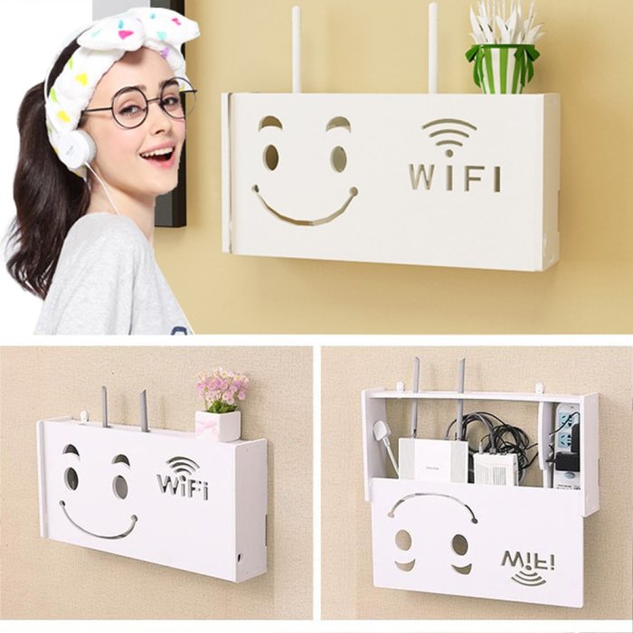 Dekorativ vägghängd förvaringsenhet för router med smiley-design och plats för kablar och tillbehör.