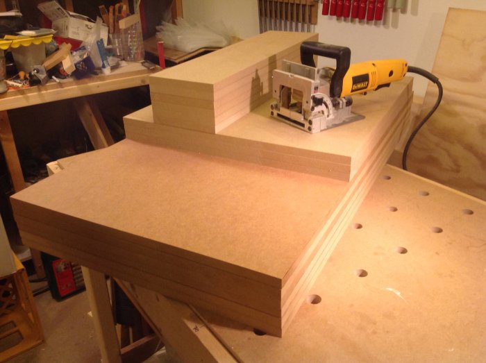 Cirkelsåg och handgjorda guider på MDF-skivor som förberedelse för skåpskonstruktion.