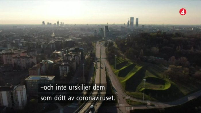 Vy över en italiensk stad med text om coronarelaterade dödsfall under nyhetssändning.