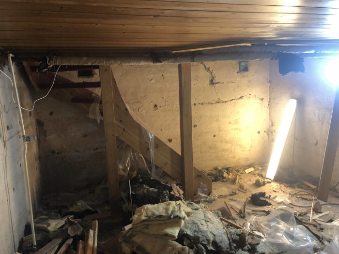 Renoveringsprojekt med rivet material och träväggar i rum från 40-talets tillbyggnad med synligt slitage.