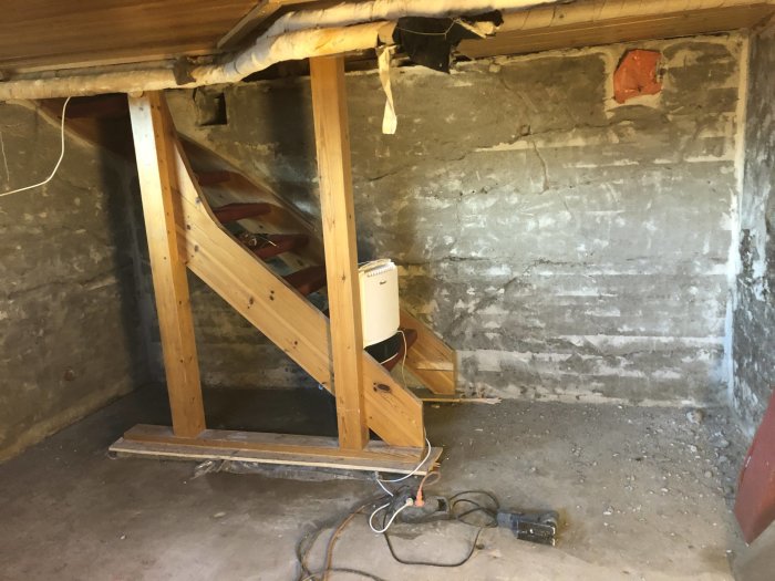 Renoveringsprojekt där betongväggar och trästöd syns i ett hus från 40-talet.