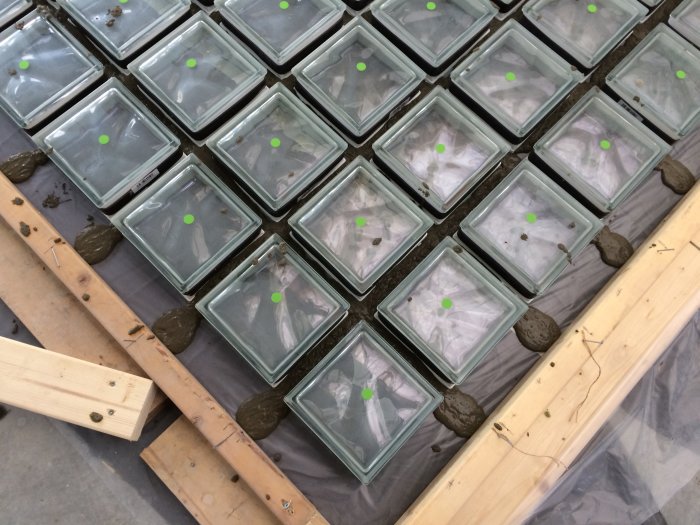 Gjutningsprocess av ett isolerat glasblocksfönster med gröna markeringar för armering.