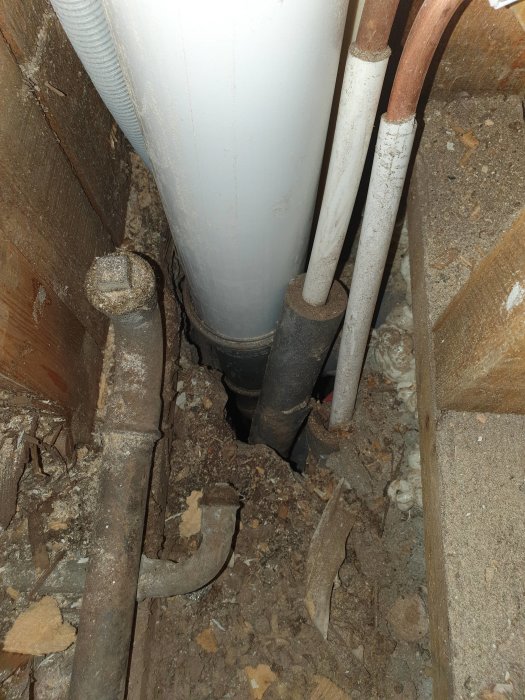 Öppning i betong med rörledningar och isoleringsmaterial runtom, i behov av tätning för att förhindra insektsintrång och fukt.