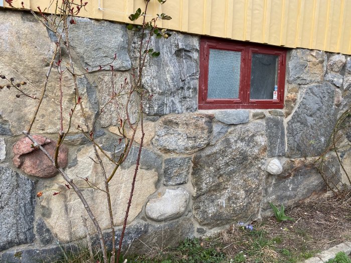 Stenblocksfundament på hus från 1923 med små öppningar där råttor kan komma in.