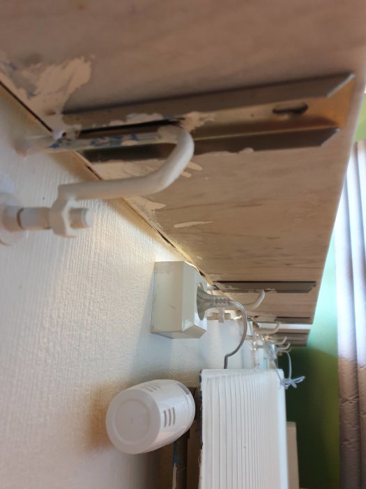 Underifrånvy av en fönsterbräda och dess konsoler med glipa och spår av tidigare limning.