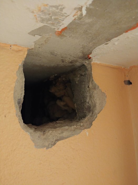 Ett befintligt hål i en vägg av lättbetong fyllt med fogskum, redo för ventilationkanaldragning.