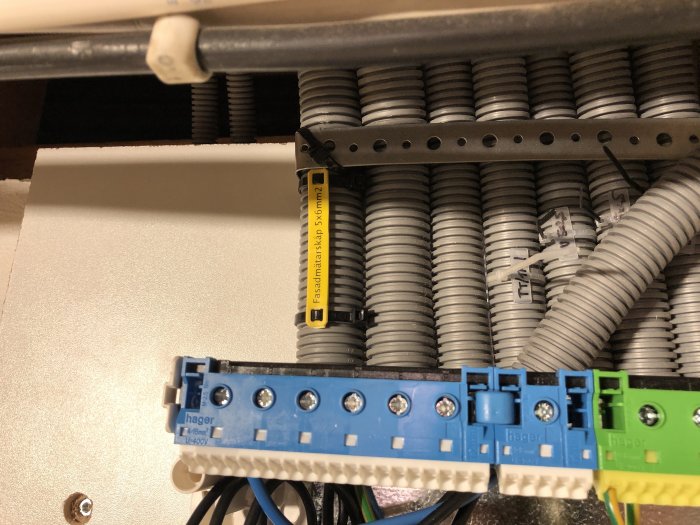 Elinstallation med kabelkanaler och Hager säkringsdosa i ett skåp.