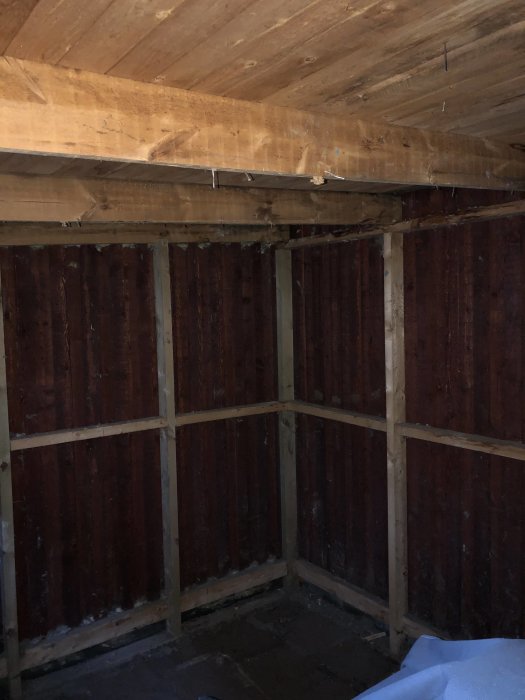 Icke-isolerat förrådsutrymme med träväggar och synliga takbjälkar.